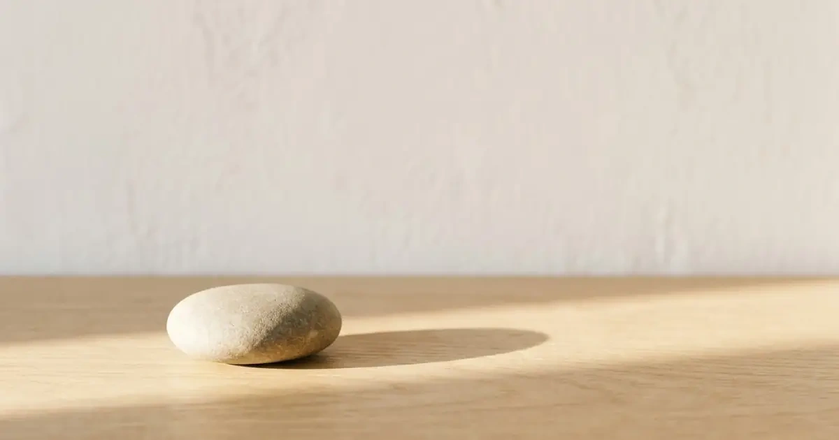A single smooth stone on a wooden surface representing how to pick a middle name simply.