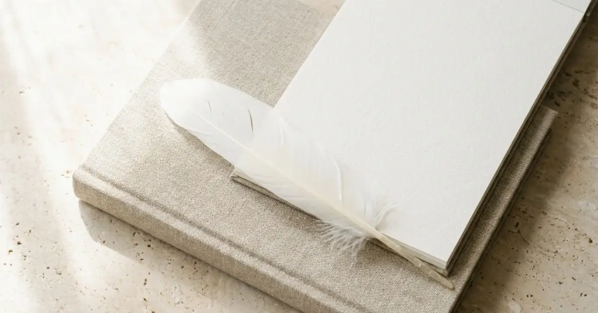 A white feather on a clean linen journal showing the quiet dignity of noble baby names.